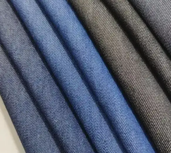 Close-up texture of modal blended denim fabric showing a smooth surface and soft indigo finish for lightweight apparel.
