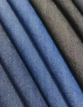 Close-up texture of modal blended denim fabric showing a smooth surface and soft indigo finish for lightweight apparel.